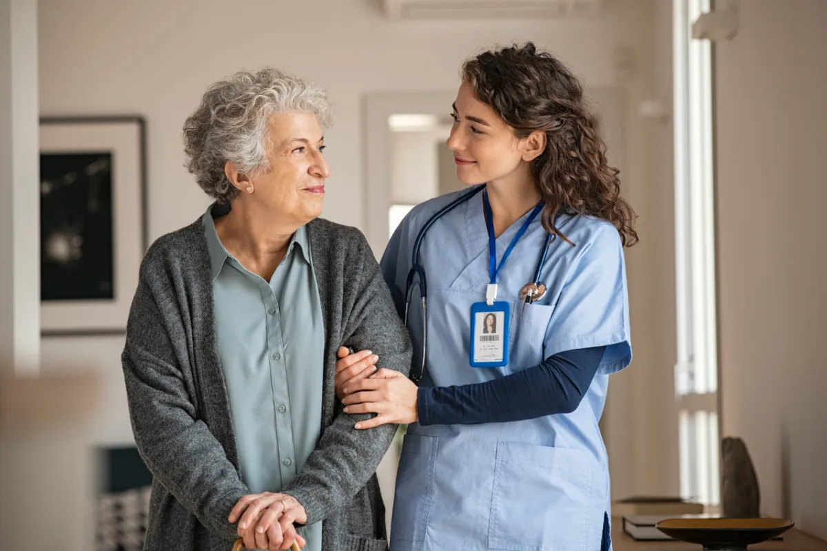 A Mily's caregiver walking arm in arm with a client, sharing a warm conversation.